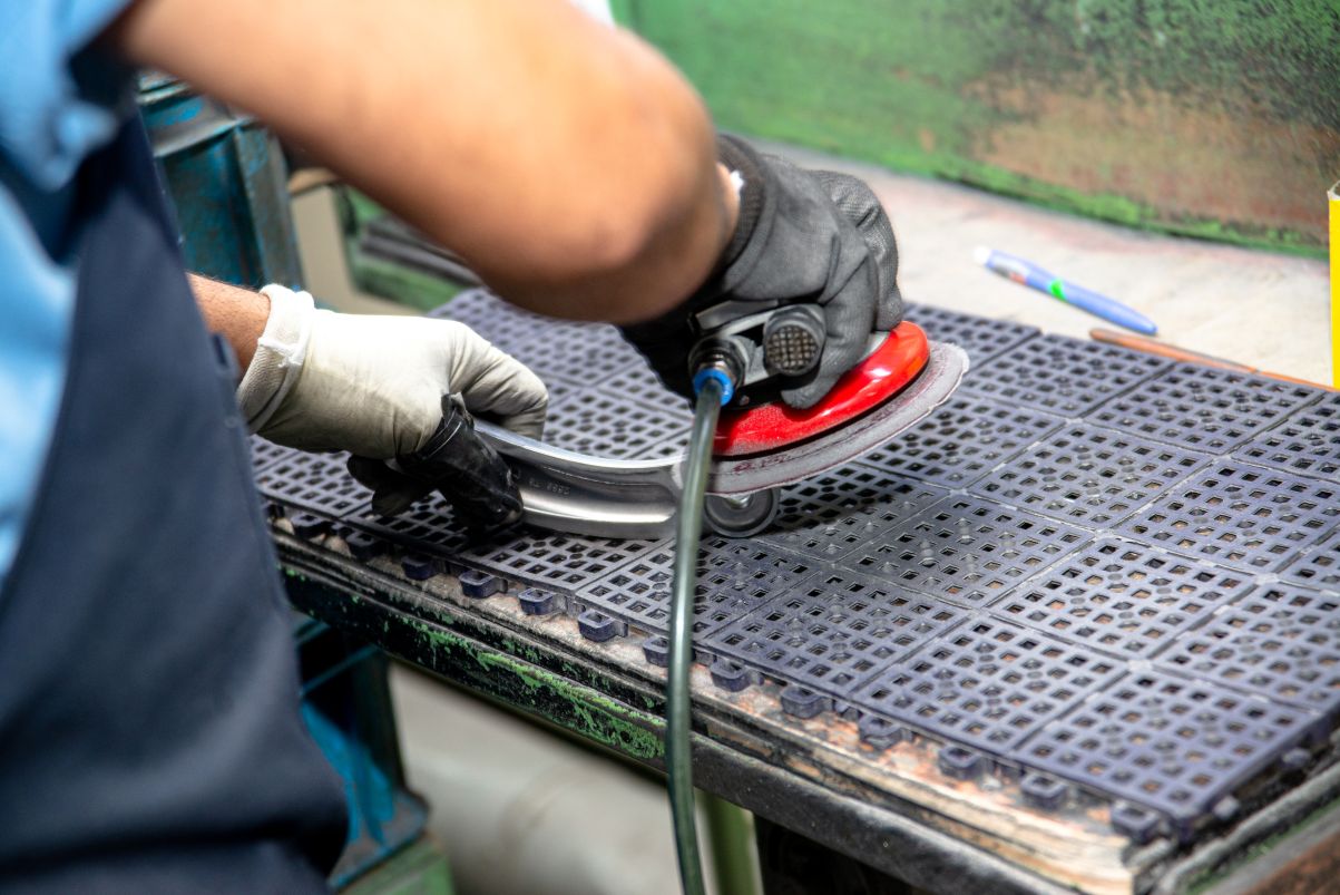 Operator performing buffing and surface finishing on a precision component